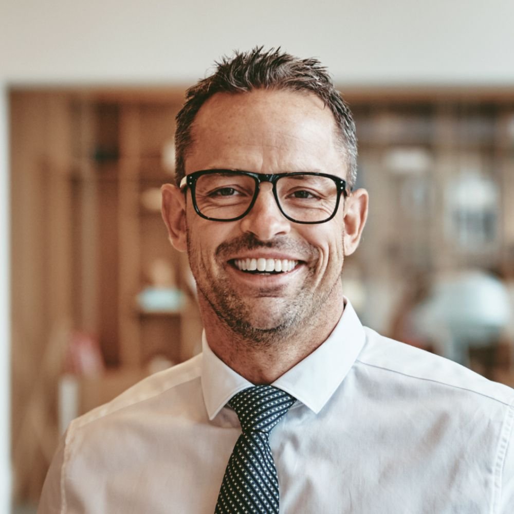smiling-mature-businessman-standing-alone-in-an-of-Y89VGBD-1-1.jpg